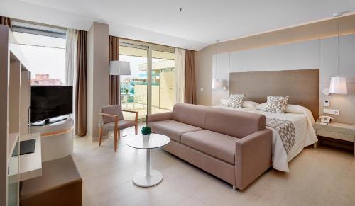 a hotel room with a bed and a couch at Hipotels Gran Playa de Palma in Playa de Palma