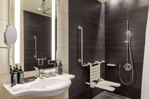 a bathroom with a sink and a shower at Vienna House by Wyndham Andel's Berlin in Berlin