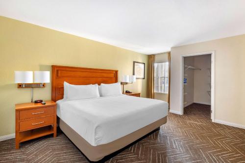 a bedroom with a white bed and a nightstand and a bed sidx sidx sidx at Hilton Vacation Club Desert Retreat Las Vegas in Las Vegas