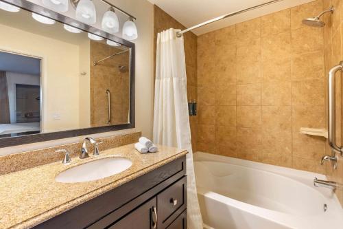 a bathroom with a sink and a tub and a shower at Hilton Vacation Club Desert Retreat Las Vegas in Las Vegas