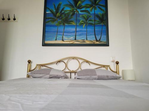 a bedroom with a bed with a painting of palm trees at Sky Home Room 1 in Amsterdam