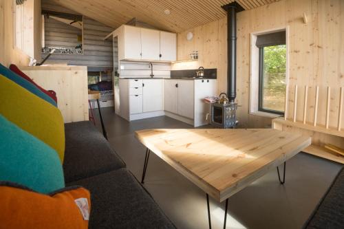 a living room with a wooden table and a kitchen at Off Grid Travel at Cambo Estate in St. Andrews
