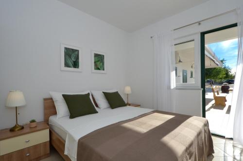 um quarto com uma cama e uma porta de vidro deslizante em House Natura em Gornji Seget