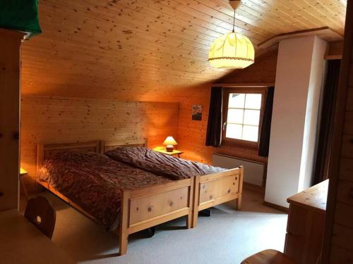 a bedroom with a bed in a wooden room at Chalet Hockenhorst, 1-10 personen -Familiechalet in fijn skigebied in Kippel