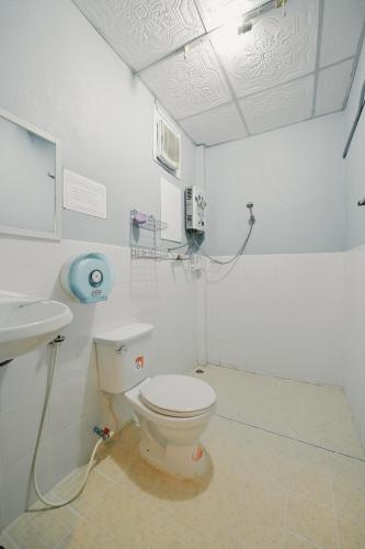 a white bathroom with a toilet and a sink at ไร่นภาดลรีสอร์ท in Mae Suai