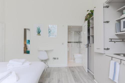 een witte badkamer met een toilet en een wastafel bij Modern Kensington Apartments in Londen