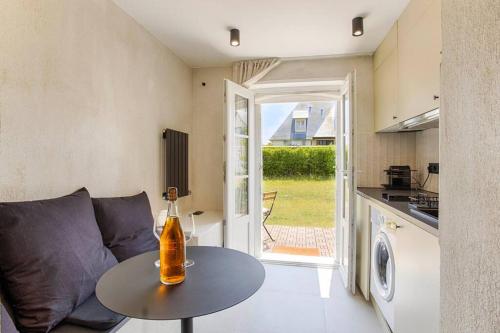 un salon avec un canapé et une table et une cuisine dans l'établissement Deauville Spa Suite - 3min beach, à Blonville-sur-Mer