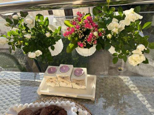uma mesa com uma bandeja de doces e flores em Boutique apartman Dora Angel em Budva