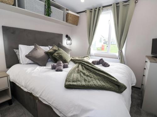 1 dormitorio con 1 cama blanca grande y ventana en Ginger Fox Lodge en Ganton