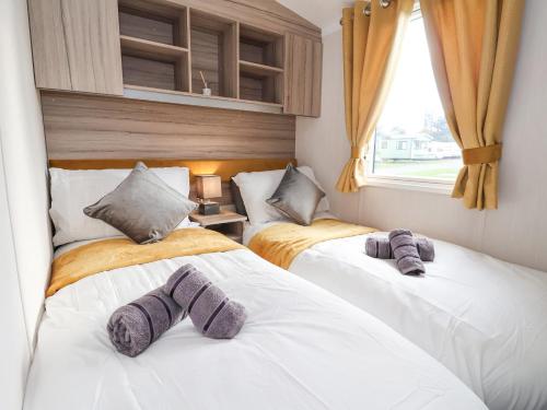 a bedroom with two beds with towels on them at Lazy Dayz Lodge in Ganton