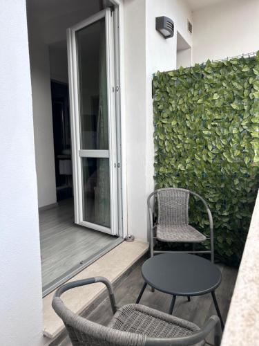 a patio with two chairs and a table and a window at Affittacamere In Centro in Tortolì