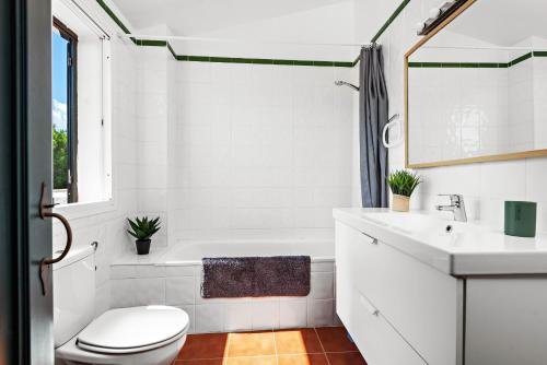a white bathroom with a toilet and a sink at Apartamento Arenal Jardin in Arenal d'en Castell