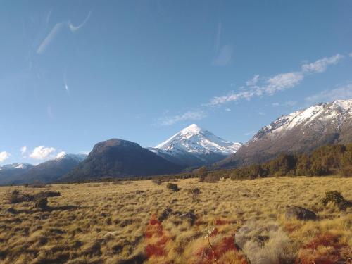 un champ avec des montagnes enneigées en arrière-plan dans l'établissement Rinconcito de CHABELA, à Junín de los Andes