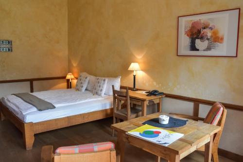 a small room with a bed and a table and a table sidx sidx at Hôtel Restaurant Le Saint-Christophe in Bex