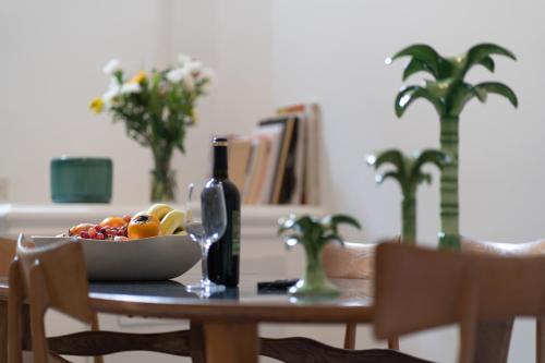 a table with a bowl of fruit and a bottle of wine at Palazzo Maritati in Nardò