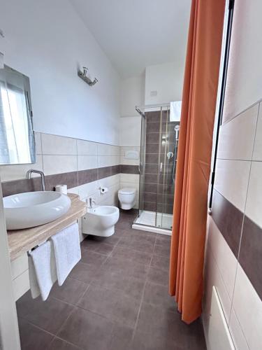 ein Bad mit einem Waschbecken, einem WC und einer Dusche in der Unterkunft Affittacamere In Centro in Tortolì