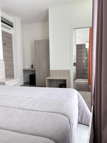 a white bedroom with a white bed and a window at Affittacamere In Centro in Tortolì