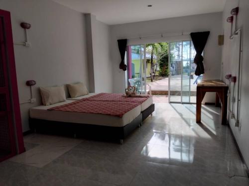 a bedroom with a bed and a sliding glass door at เขาหลัก ซัมเมอร์เฮาส์ 2 in Khao Lak