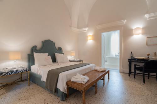 ein Schlafzimmer mit einem großen Bett und einem Schreibtisch in der Unterkunft Palazzo Maritati in Nardò