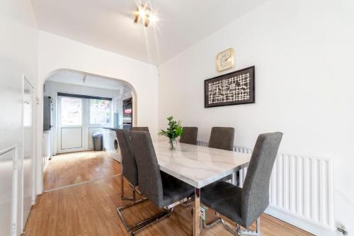 a dining room with a table and chairs at Stunning 3 Bed House with Private Garden, Woolwich in London