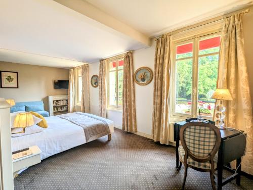a bedroom with a bed and a desk and windows at Château Corneille in Vieux-Villez