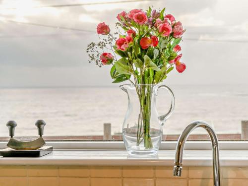 a vase filled with flowers sitting on a kitchen counter at 4 Bed in Ogmore-by-Sea 74236 in Saint Brides Major