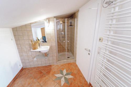 a small bathroom with a sink and a shower at Schlafgut Küssler - 70m vom City Express in Zell am See