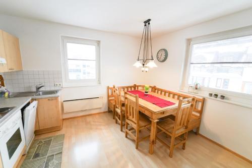 a kitchen with a table with chairs and a clock on the wall at Schlafgut Küssler - 70m vom City Express in Zell am See