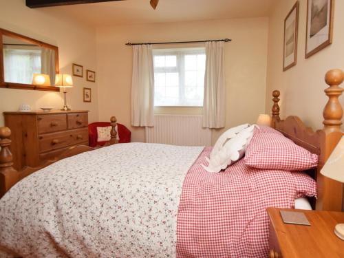 a bedroom with a bed and a dresser and a window at 1 Bed in Winfrith Newburgh 75156 in Winfrith Newburgh