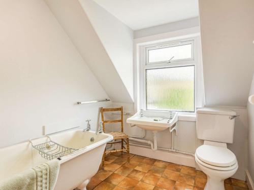 a bathroom with a white tub and a sink at 4 Bed in Kinlochewe CA179 in Kinlochewe