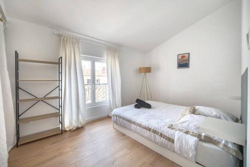Una habitación blanca con una cama y una ventana en Superbe appartement, hypercentre, 4chambres., en Béziers