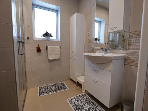 a white bathroom with a sink and a shower at Chaloupka Na Pivovaře Seč in Seč