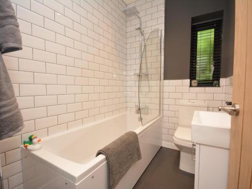 a white bathroom with a tub and a toilet at 1 bed property in Gilwern Brecon Beacons 75206 in Gilwern