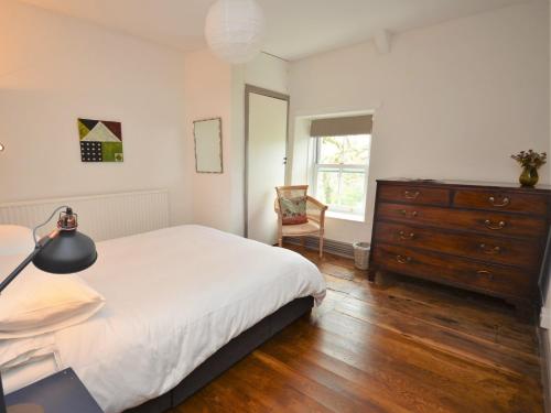 1 dormitorio con 1 cama, vestidor y silla en 3 Bed in Llandovery 76381 en Ystrad-ffin