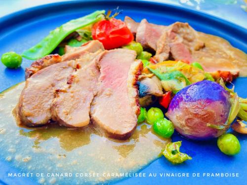 a blue plate of food with meat and vegetables at Château Corneille in Vieux-Villez
