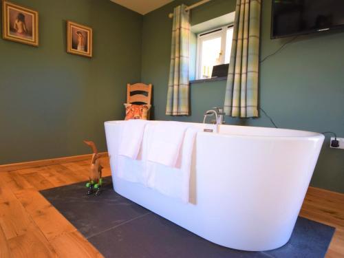 a white bath tub in a room with a window at 1 Bed in Croyde 75270 in Marwood