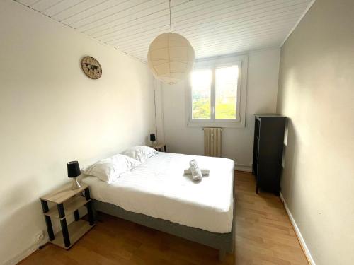 um pequeno quarto com uma cama e uma janela em Grand 2 chambres & parking em Besançon
