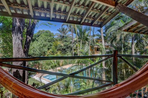a hammock in a tree house with a view of the jungle at Pousada Villa N'kara in Itacaré