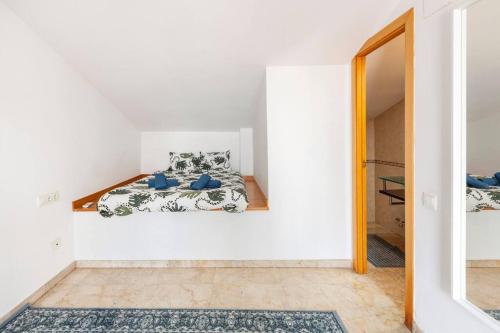 een witte kamer met een bed en een spiegel bij First sea line nice duplex with terrace in Arenys de Mar