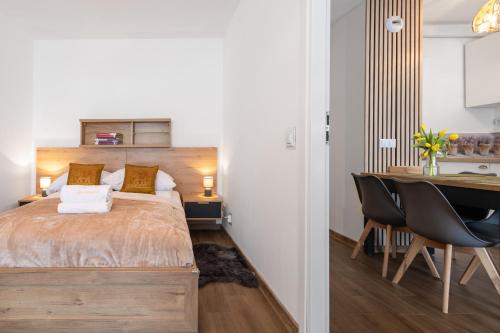 a bedroom with a bed and a table and a desk at Apartamenty Cicha - bezpłatny parking in Krynica Zdrój
