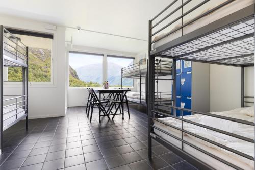 Trolltunga Hostel في Tveit: غرفة بها سرير بطابقين وطاولة فيها