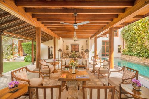 an indoor patio with a pool and tables and chairs at Ishq Colombo in Colombo
