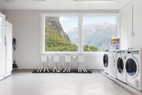 a laundry room with a window and washing machines at Trolltunga Hostel in Tysso