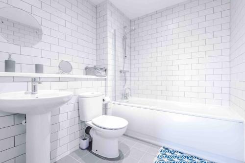 uma casa de banho branca com um WC e um lavatório em 2 Bedroom Manchester Gem Ancoats em Manchester