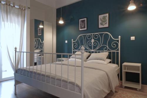 um quarto com uma cama e uma parede azul em You & Me Cozy Apartments em Atenas