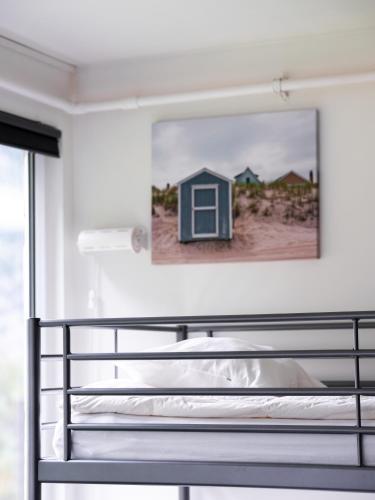 a bedroom with a bed and a painting on the wall at Trolltunga Hostel in Tysso