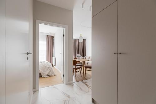 Pokój z białymi ścianami i sypialnią ze stołem w obiekcie LET'S SEA - 4 Person - Premium Baltic Apartment with Sea View nad SPA access w Gąskach