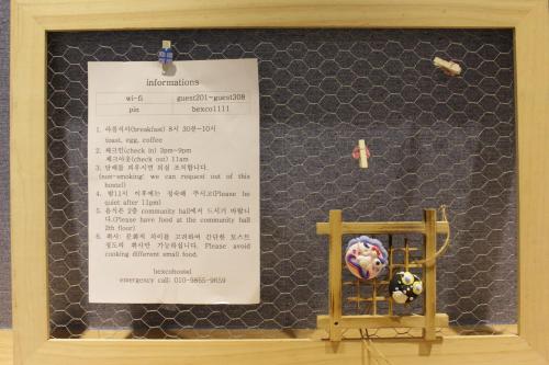 a wall with a piece of paper and a sign at Bexco Hostel B&B in Busan