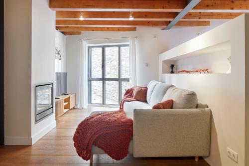 ein Wohnzimmer mit einem Sofa und einem TV in der Unterkunft Val Arties 1 by FeelFree Rentals in Arties