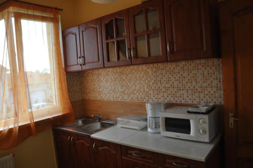 a kitchen with a sink and a microwave at Maros Vendégház in Mórahalom